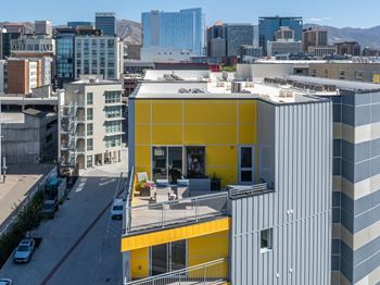 A yellow and grey building with a balcony in the middle.